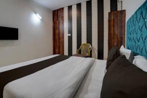 a bedroom with a large bed and a tv at Hotel O Swastik Inn in Chinhat