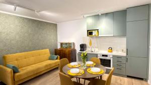 a living room with a table and a yellow couch at APARTAMENT Nowoczesny PRL in Bydgoszcz