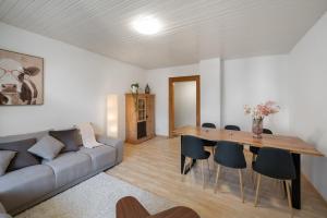 a living room with a couch and a table and chairs at Apartment Troya in Unterseen