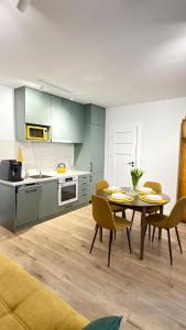 a kitchen and dining room with a table and chairs at APARTAMENT Nowoczesny PRL in Bydgoszcz