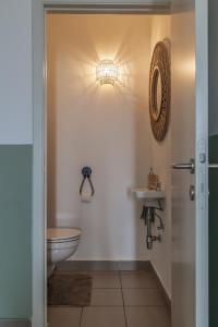 a bathroom with a toilet and a sink at Warvinge 73 in De Haan +32 photos