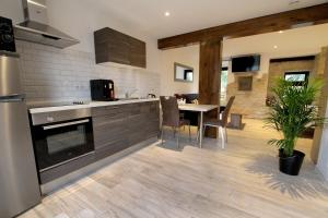 cocina con mesa y comedor en Le Moulin d'Oscar & Spa - Mulhouse Nord, en Baldersheim