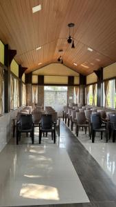 a large dining room with chairs and tables at The Den by Trees in Kotagiri