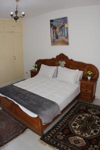 a bedroom with a large bed with a wooden frame at Cozy Central Nahda in Rabat