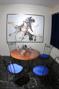 a table and chairs with a painting on the wall at Cozy Central Nahda in Rabat