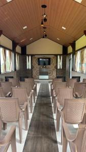 a row of chairs in a room with a tv at The Den by Trees in Kotagiri