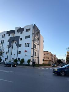 a large white building on the side of a street at Cozy Central Nahda in Rabat