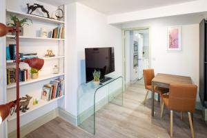 a dining room with a glass table and a television at Modern Flat on the seafront Exmouth in Exmouth