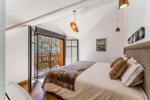 a bedroom with a bed and a balcony at Villa Saint Brice, frontline in Arès +52 photos