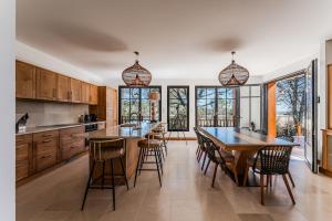 a kitchen with wooden cabinets and a table and chairs at Villa Saint Brice, frontline in Arès