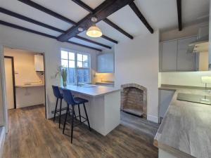 a kitchen with a counter and chairs in a room at The Indigo Escape in Ibstock