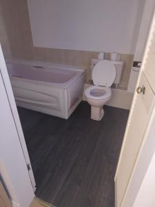 a bathroom with a toilet and a tub and a sink at Cristabel Guest House in Clacton-on-Sea
