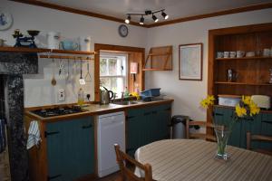 a kitchen with blue cabinets and a table with a tableablish at The Loan in Achiltibuie