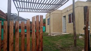 a wooden fence in a yard next to a building at Altos de la Villa House in Concepción del Uruguay