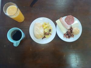 a table with two plates of food and a cup of coffee at Pousada São João in São Thomé das Letras