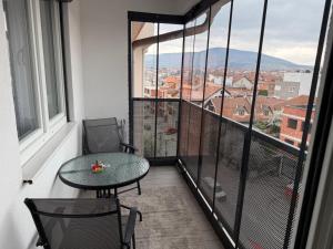a balcony with a table and chairs and a view at Eda's Home in Mitrovica