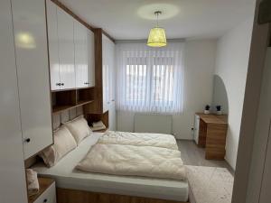 a bedroom with a bed and a desk and a window at Eda's Home in Mitrovica
