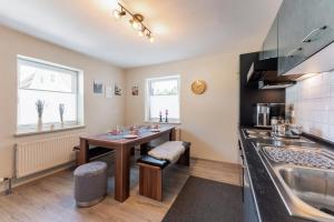 a kitchen with a table and a sink at Haus MALEA by Wohn-Zeit - über 200 Betten im Umkreis von 87700 Memmingen in Fellheim