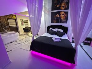 a bedroom with a bed with a pink lighting at Luxury Central Studio in Craiova