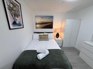 a bedroom with a bed with a towel on it at Sleek 1BR Flat Perfect Getaway For Contractors Or Couples in Cardiff