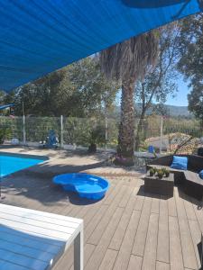 a patio with a blue umbrella and a swimming pool at Spa Ibiza Dosrius - Bungalow con Jacuzzi y Piscina privada in Canyamás