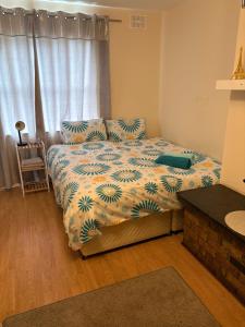 a bedroom with a bed with a blue and white comforter at Riverchapel Guesthouse in Courtown
