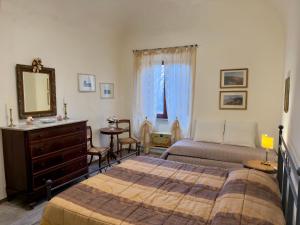a bedroom with a bed and a dresser and a mirror at Casa Falconcini in Volterra