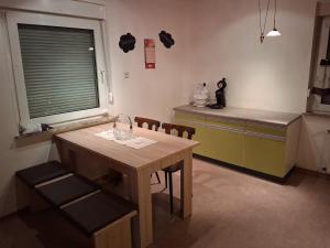 a kitchen with a wooden table and chairs and a counter at Unterkunft mit Kindernische in Ober-Mörlen