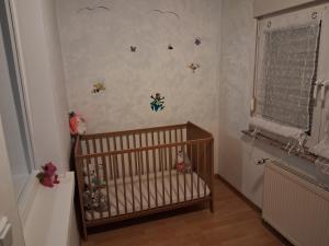 a baby room with a crib and some bugs on the wall at Unterkunft mit Kindernische in Ober-Mörlen