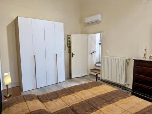a bedroom with two large white cabinets and a bed at Casa Falconcini in Volterra