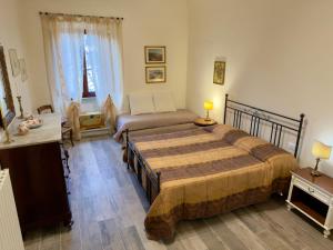 a bedroom with two beds and a desk and a bed at Casa Falconcini in Volterra