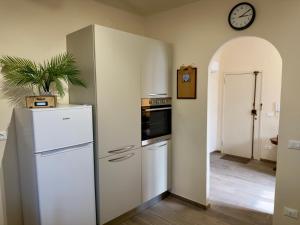 a kitchen with a refrigerator and a clock on the wall at Casa Falconcini in Volterra +3 photos
