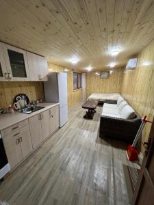 a living room with a couch and a kitchen in a tiny house at Bardzunq Garden Resort in Goghtʼ