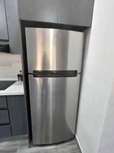 a stainless steel refrigerator in the corner of a kitchen at Riverside Apartments in Jacó