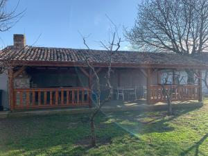 a house with a wooden porch with a deck at Casa Gheorghe in Balabancea