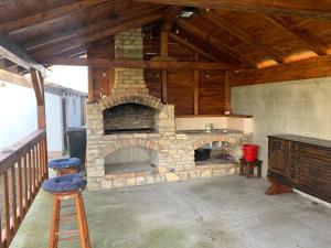 a stone fireplace in a house with a wooden ceiling at Casa Gheorghe in Balabancea