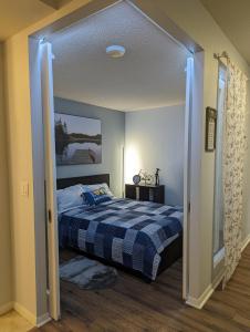 ein Schlafzimmer mit einem Bett mit einer blau-weißen Decke in der Unterkunft Downtown Condo with Free Parking - SkySide in Toronto + 18 Fotos