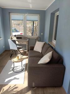 a living room with a couch and a desk at Hotel Haus Mönchgut in Thiessow