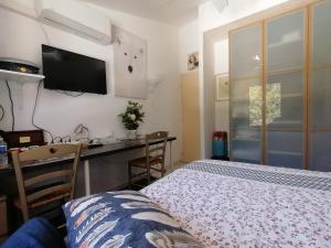 a bedroom with a bed and a desk and a tv at Yuca in Vallauris +30 photos