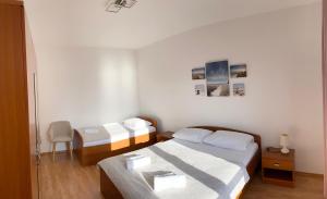 a small bedroom with two beds and a table at Apartment Duda in Starigrad