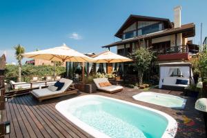 a swimming pool on a deck next to a house at Refúgio das Galés Mariscal in Bombinhas