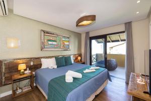 a hotel room with a bed with towels on it at Refúgio das Galés Mariscal in Bombinhas
