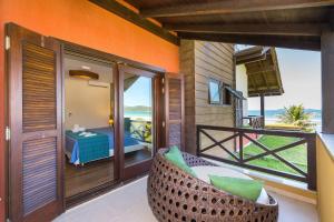 a room with a balcony with a view of the ocean at Refúgio das Galés Mariscal in Bombinhas