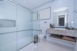 a bathroom with a toilet and a sink and a shower at Refúgio das Galés Mariscal in Bombinhas +93 photos