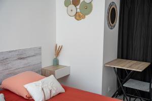 a bedroom with a bed and a chair and a clock at Maison de ville Libourne 3 chambres in Libourne