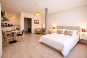 a bedroom with a large white bed and a kitchen at L'Atelier No 8 in Saverne