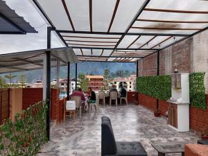 a patio with people sitting at tables under a pergola at La Terraza de Huaruro in Cabanaconde