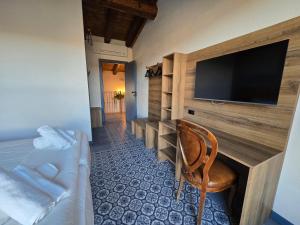 a room with a desk with a television and a chair at Agriturismo Maison Oro Verde in Verona