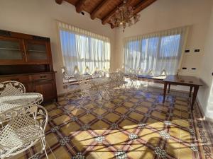 a room with chairs and a table and windows at Agriturismo Maison Oro Verde in Verona