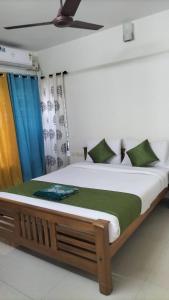 a large bed in a room with blue curtains at HK villas in Edappally